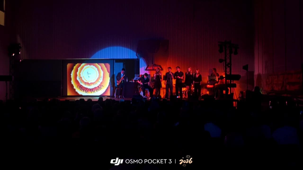 XMOS band on stage at Sint-Ludgardis Antwerp, lit by a spotlight